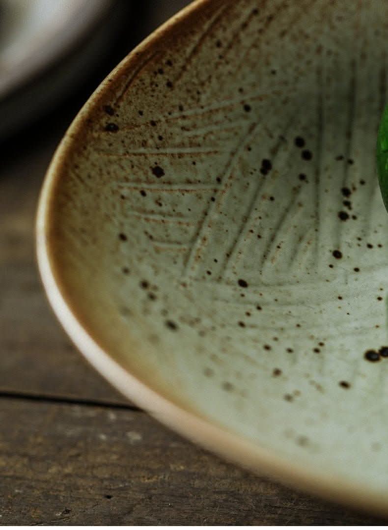 Tripod Stoneware Fruit Plate: Earthy ceramic with speckled finish on wood table